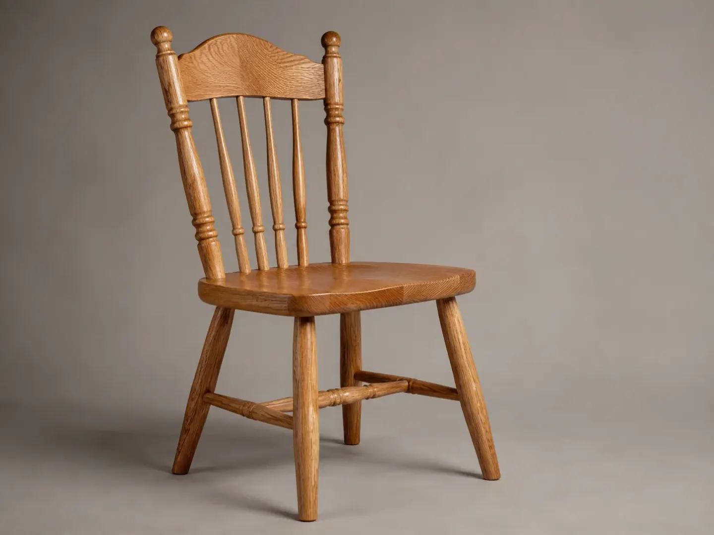 Hand-turned solid oak spindle-back dining chair on a neutral studio backdrop.